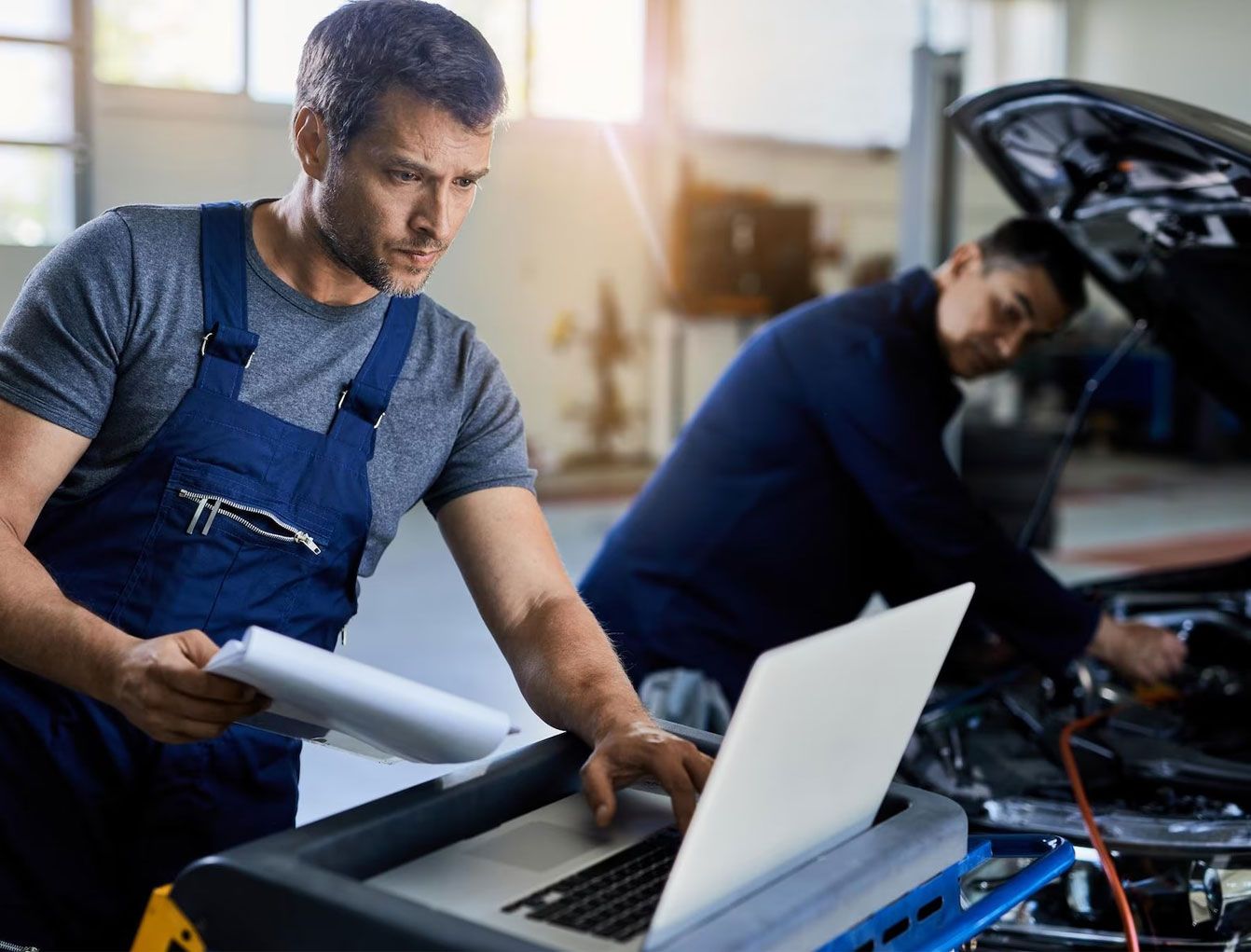Technician running vehicle diagnostics on a laptop