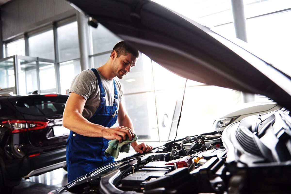 Technician working under an open bonnet
